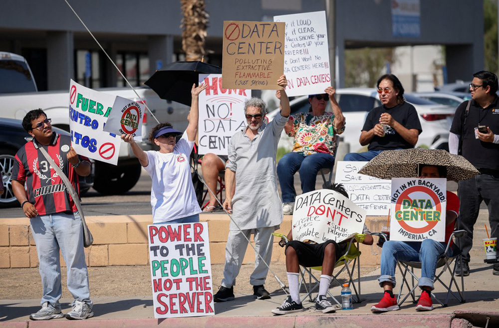 Demonstrators wave signs during a nationwide protest against AI data center expansion in Imperial, California on July 18, 2026. (Photo by SANDY HUFFAKER / AFP)