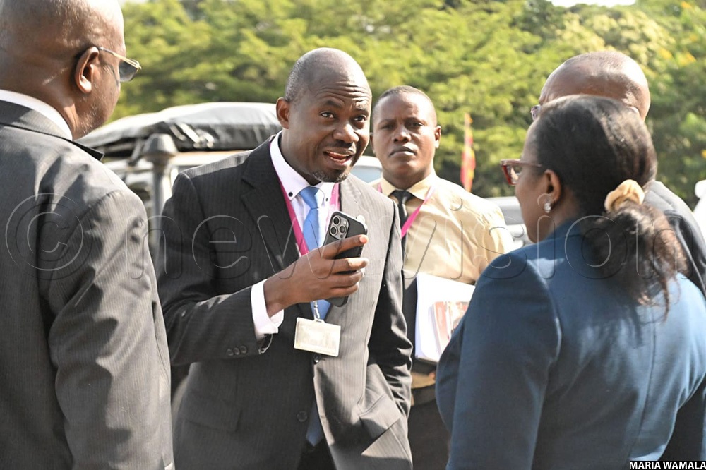 Acting Chief Executive Officer (CEO) Dr. Protazio Sande (man)and Director Legal Affairs Francesca Kakooza (lady) leave after appearing before COSASE