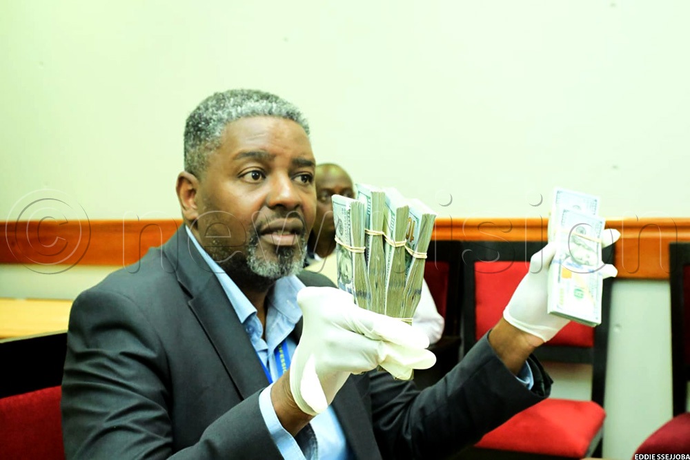 Robert Kalumba, the URA assistant commissioner for Public and Corporate Affairs, displays the USD 60,000 (sh223m) as an exhibit in bribery allegations against a senior staff, Geoffrey Ssozi, the Manager, External Operations Customs in Dar-es-Salaam. (Photo by Eddie Ssejjoba)