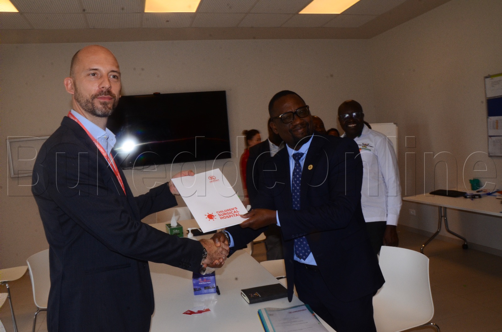 Asso.Prof we Makerere University Bruce Kirenga nga akwasibwa ebbaluwa okuva ewa Giacomo Menaldo akulira eddwaliro lya Children's Surgical Hospital e Ntebe ekakasa enkolagana etandikibwawo okutendeka abayizi.
