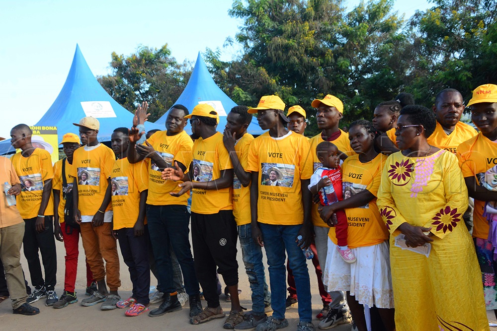 State Minister for Public Service (on right holding NUP card) posing for a photo with the defectors after she dressed them in NRM T-shirts. (Photo by Peter Abaanabasazi)