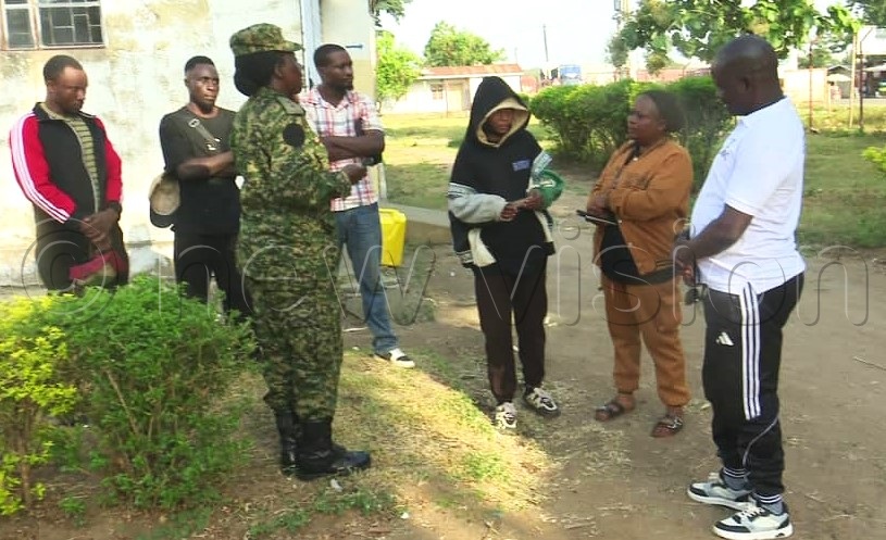 Pakwach deputy resident district commissioner Twaib Achile&nbsp;(wearing a white T-Shirt) with a soldier after intercepting the Congolese nationals in a private vehicle travelling to Kampala.