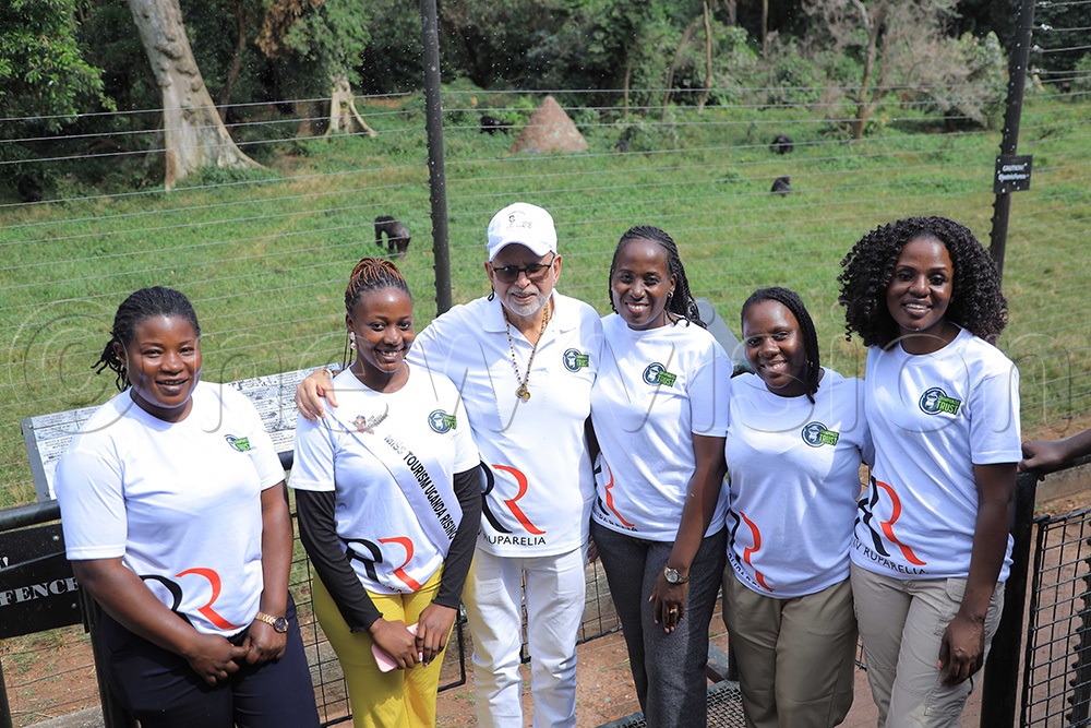 Sudhir Ruparelia (3rd left) having a photo moment with some staff at Ngamba Chimpanzee Sanctuary on Saturday. (Photo by Julius Luwemba)