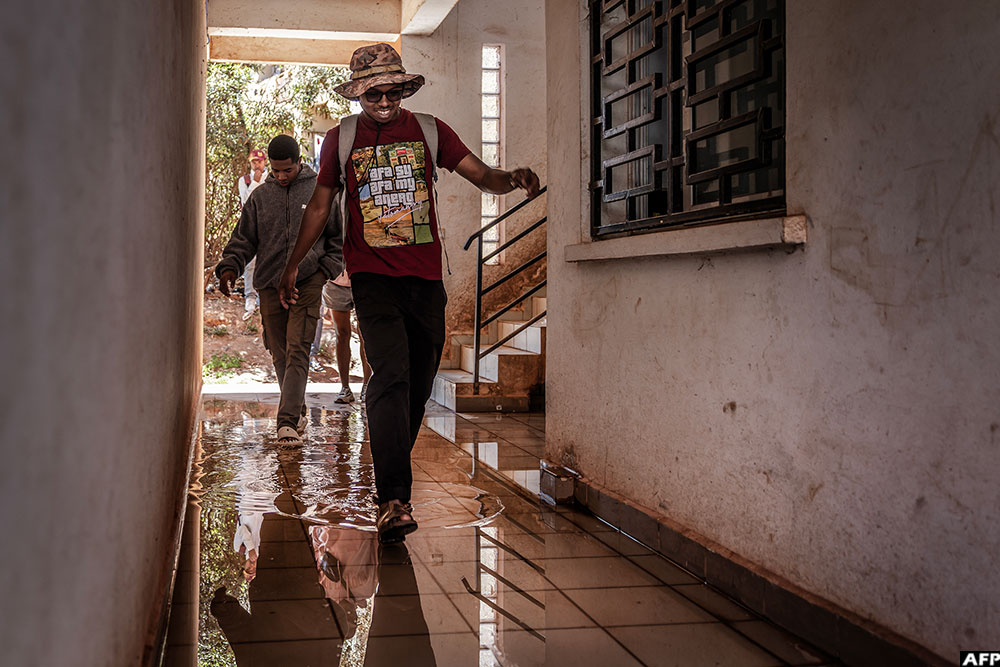 Ulric Sambizafy, 24, a student at the University of Ankatso, walks through a corridor flooded with water inside a deteriorating dormitory affected by recurring water and power shortages in Antananarivo, on October 8, 2025. (AFP)