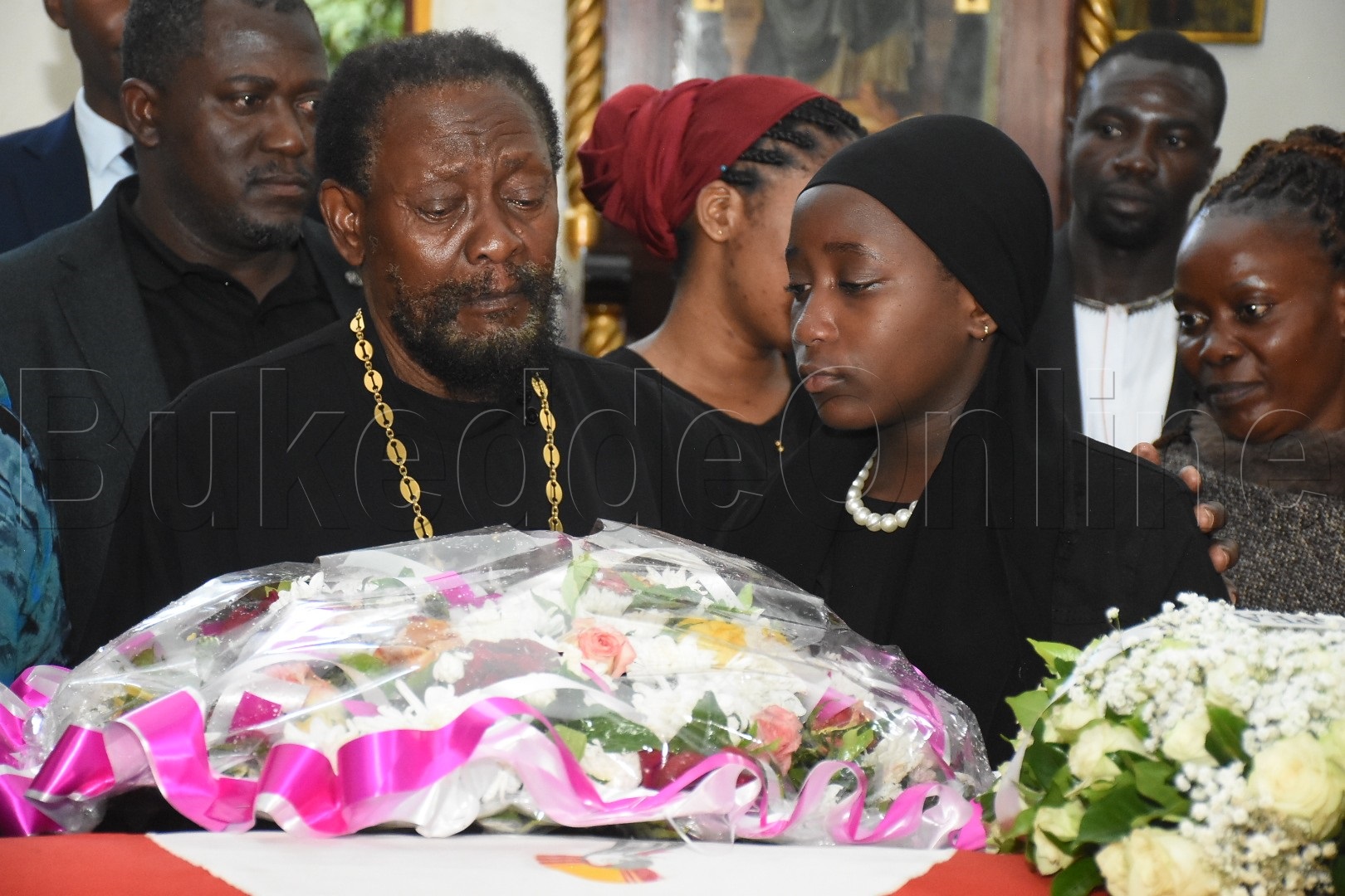 Taata w'omugenzi Christopher Walusimbi ne muwala wa Nakimuli nga bateeka ekimuli ku mugenzi