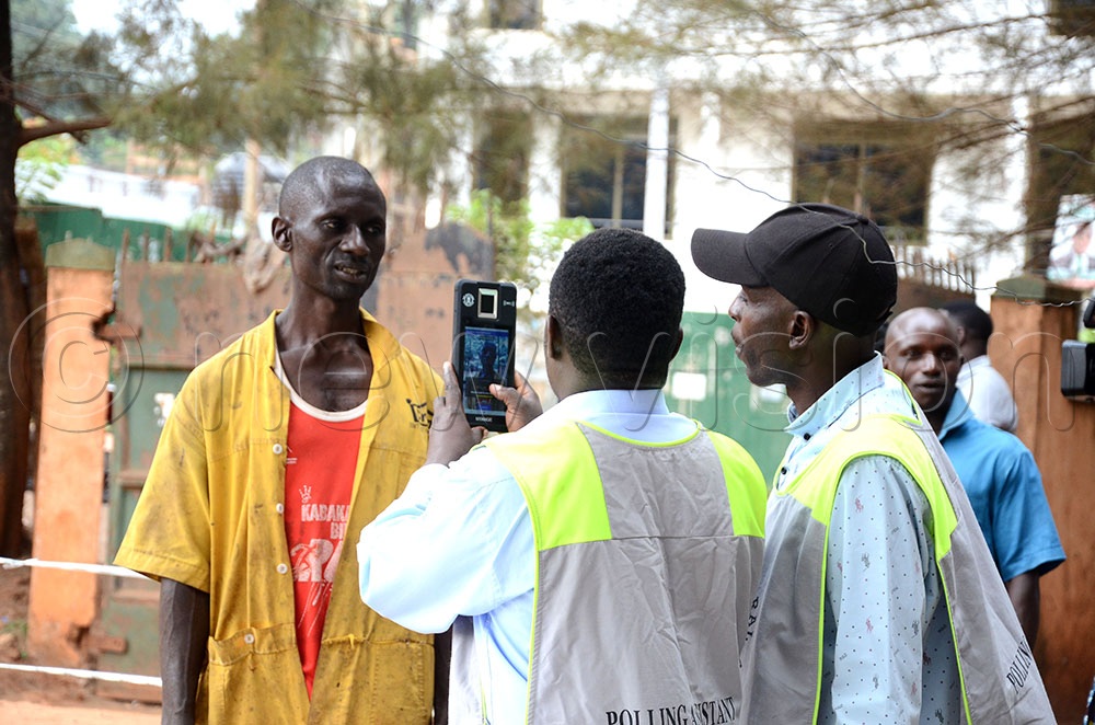 Electoral Commission polling officers using a Biometric Voter Verification machine to verify a voter during the municipality, city division chairpersons and councillors&rsquo; elections at Kampala University polling centre, Mutundwe, Kampala on January 27, 2026. (Credit:  Lawrence Mulondo)