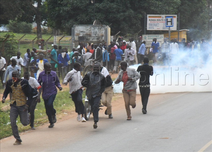 Abantu Nga Badduka Ekibambulira Kya Ttiyagaasi Eyabadde Akubwa Okubagumbulula Okuva Mu Luguudo Wakati.