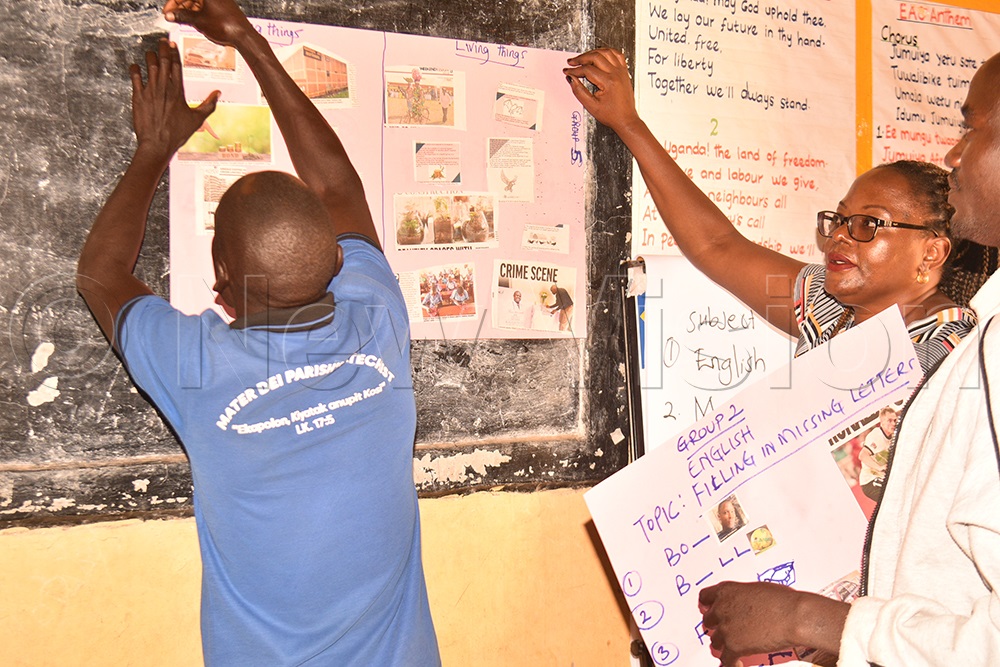 Teachers putting up teaching materials they have generated from the newspaper to be used in teaching pupils. (Credit: Jacky Achan)