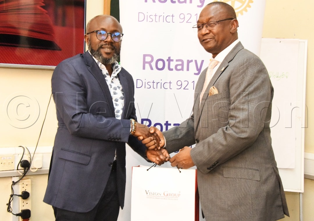 Don Wanyama (left) gives a gift to Geoffrey Martin Kitakule, Rotary District Governor D9213. (Credit: Mpalanyi Ssentongo)