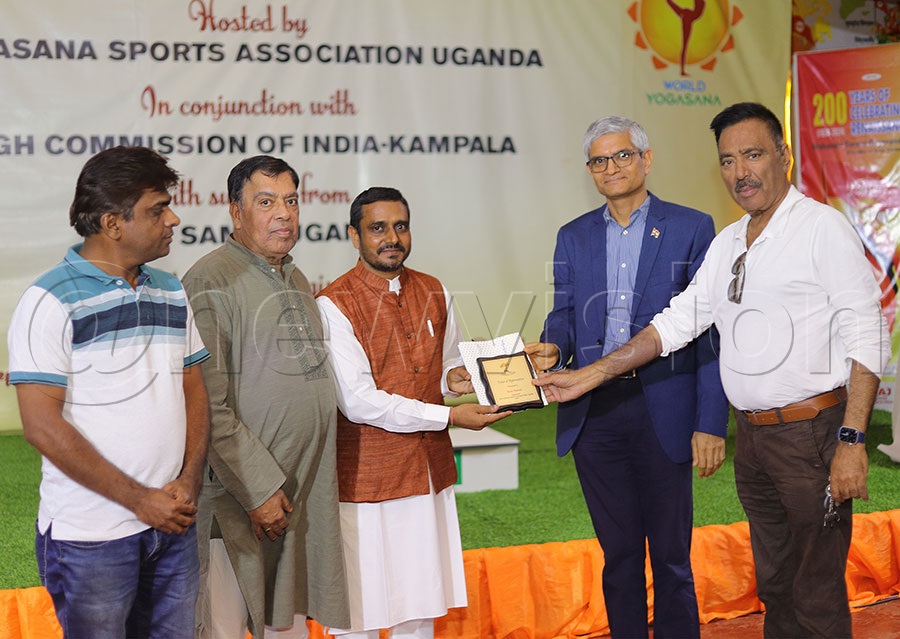 The Organisers  and sponsors of the Yogasana Tournament,hand over a plaque to the Indian High Commisioner in Kampala, Upender Singh Rawat (2nd right) in appreciation of his support to the sport. PHOTO: Johnson Were
