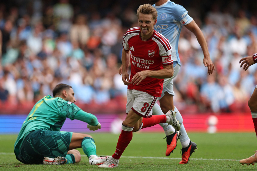 Arsenal's Norwegian midfielder #08 Martin Odegaard reacts after scoring their third goal during the English FA Community Shield football match between Arsenal and Manchester City at The Principality Stadium, in Cardiff, south Wales on August 16, 2026.