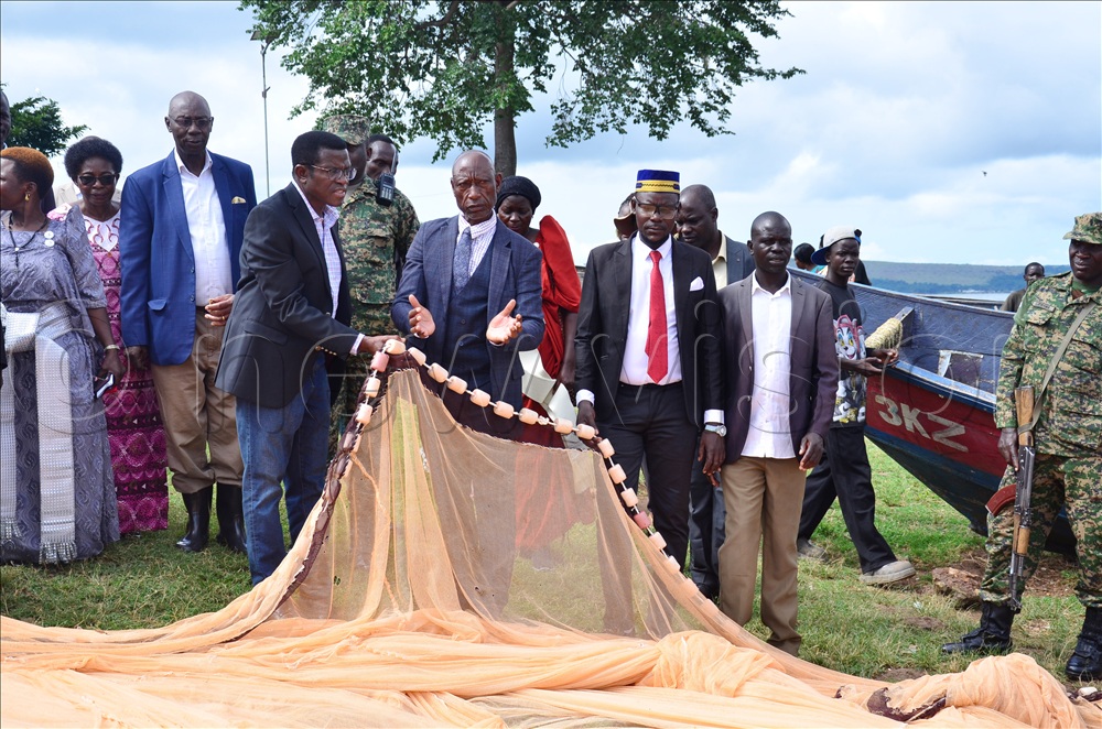 Michael Mbowa Wamala, the Buvuuma sub-county chief showing Katikkiro the recommended fishing nets at Kasaali B landing site in Buvuuma Isand.