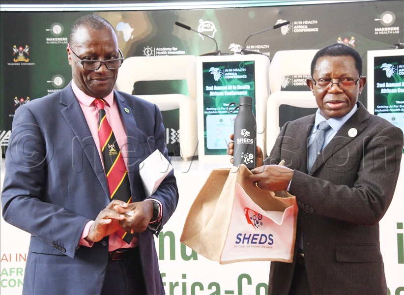 Makerere University's Prof.Buyinza Mukadasi (R) receiving a gift from Dr. Andrew Kambugu (L), ED, Infectious Disease Institute. This was at the opening of the 2nd annual AI in health, African conference at Makerere University on Thursday, November 6, 2025.