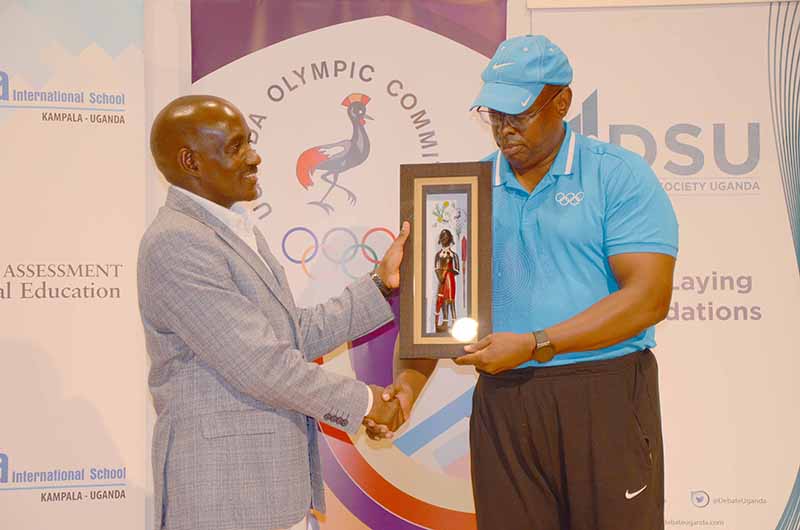 Rukare (ku ddyo) ng'akwasa akulira essomero lya Sam Turya ekirabo. Kabojja, 