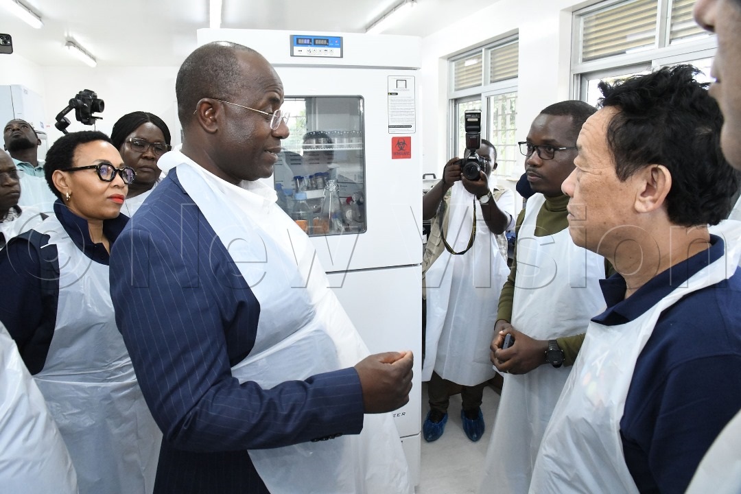 FAO director general Dr Qu Dongyu (right) and Minister Fred Bwino Kyakulaga (left) as the team toured the laboratories at the facility.