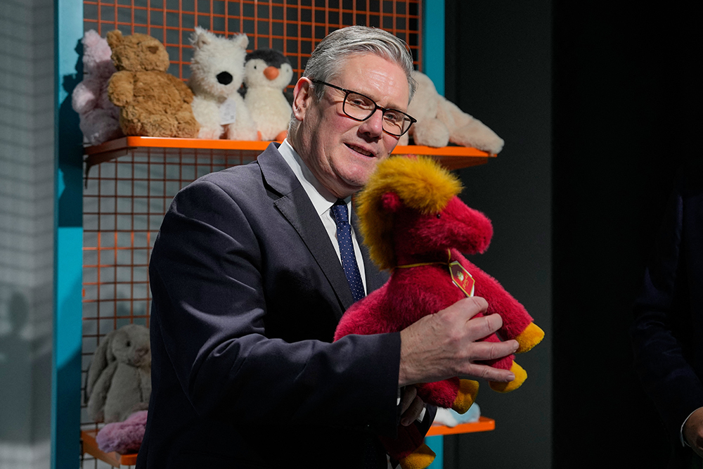 Britain's Prime Minister Keir Starmer holds up a horse doll at House of UK reception in Shanghai on January 30, 2026. (AFP)