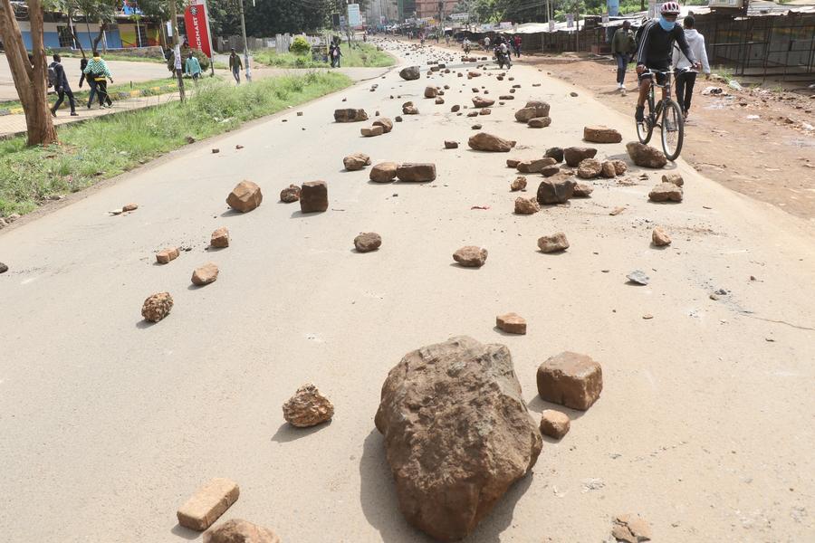 People make their way along a road blocked by barricades during demonstrations in Nairobi, capital of Kenya, May 18, 2026.