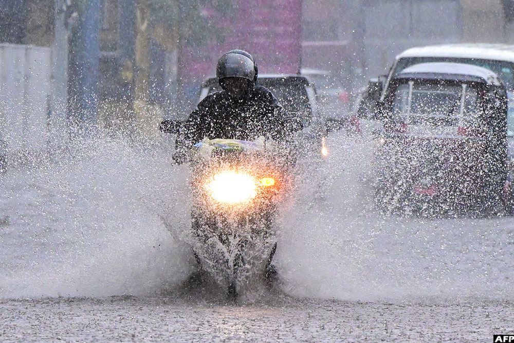 Commuters drive through a flooded street amid heavy rains in Colombo, Sri Lanka on December 5, 2025.