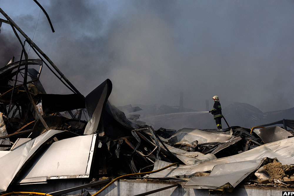 A Ukrainian firefighter works to put out a fire following massive Russian ballistic missile and drone strikes in Kyiv on August 5, 2026. (AFP)