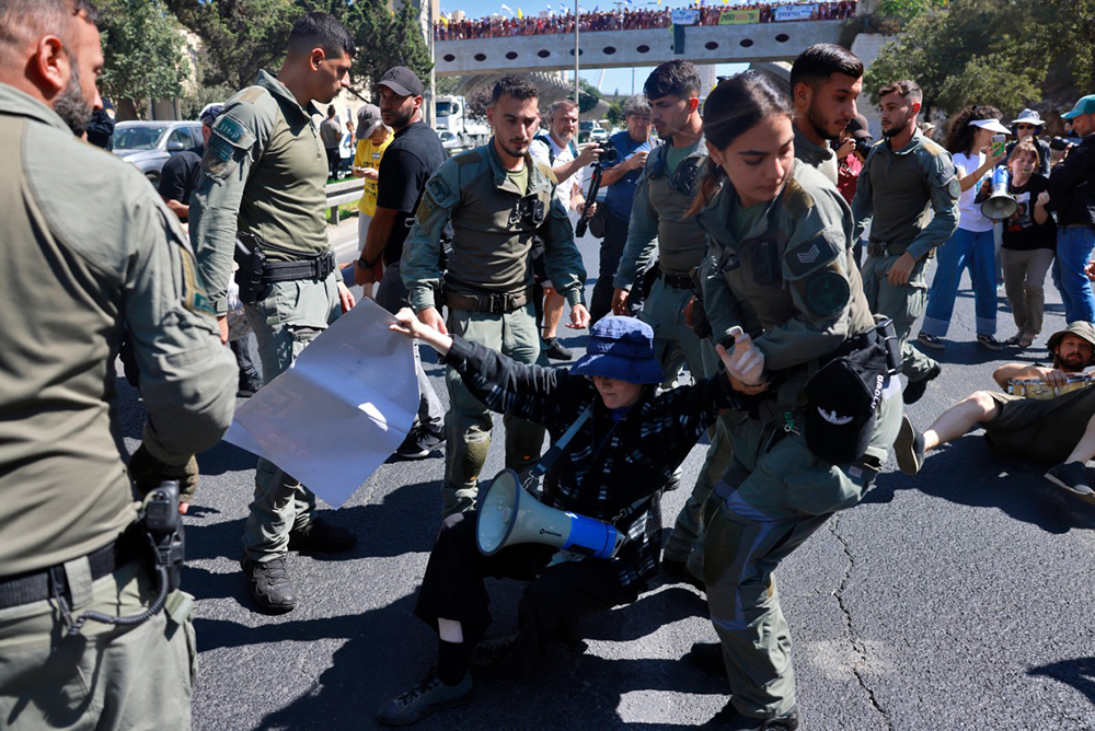 Security forces remove a protester from a street during a demonstration by families and supporters of Israelis held hostage by Hamas militants in Gaza since the October 7, 2023 attacks, calling for government action to secure their release in Jerusalem on August 17, 2025. (Photo by Menahem Kahana / AFP)