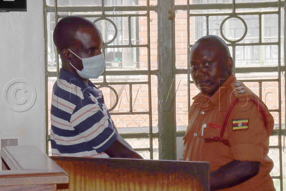 Prison Officer put hand cuff  on Kenneth Opio, 37, accused of abducting Elizabeth from Lira Timber Yard in East Division on April 8, 2021. (Credit: Hudson Apunyo)