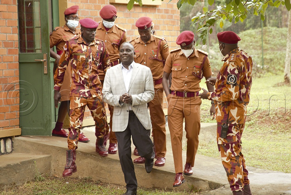 Uganda Prisons officers lead handcuffed Butambala County Member of Parliament Muhammad Muwanga Kivumbi to court where his terrorism charges were amended. (Credit: Simon Ssekidde)