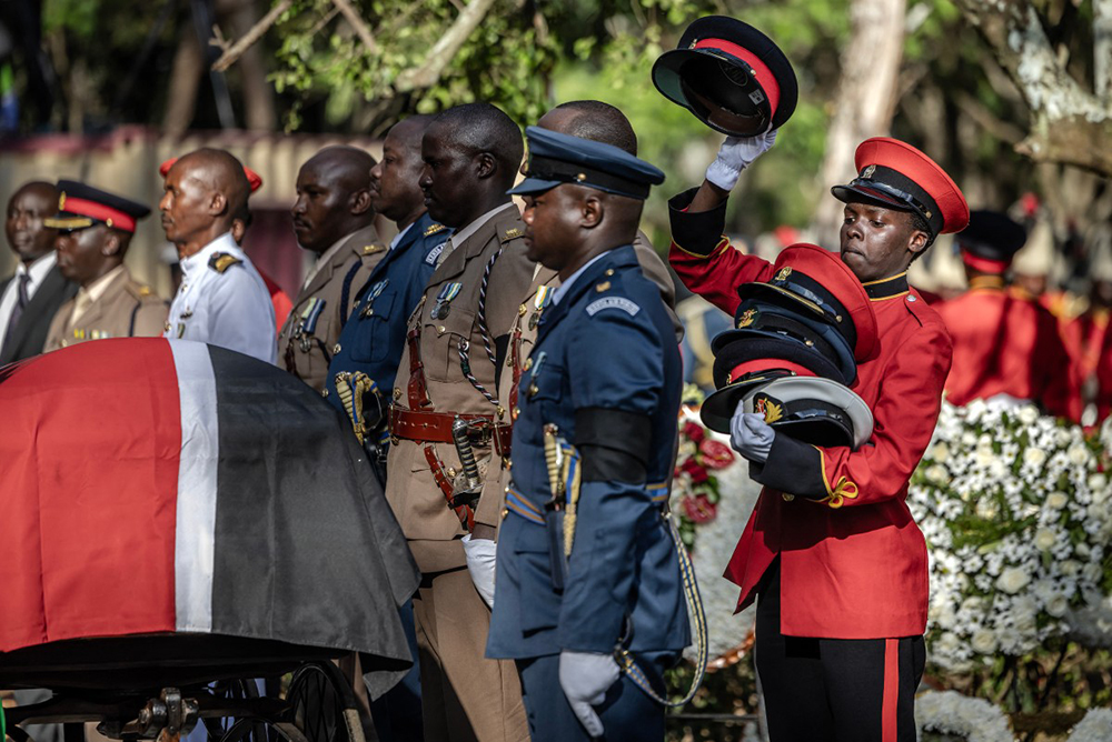 A military officer removes the caps of senior military officials serving as pallbearers standing before the coffin of Kenya’s opposition leader and former Prime Minister Raila Odinga during his burial ceremony in Bondo, on October 19, 2025. 