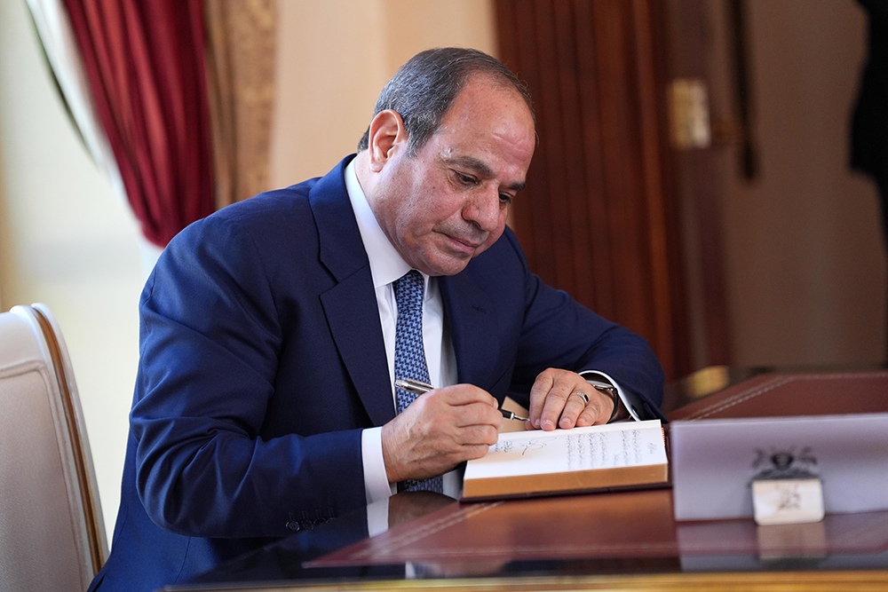 Egyptian President Abdel Fattah El-Sisi signs in the book. (PPU)
