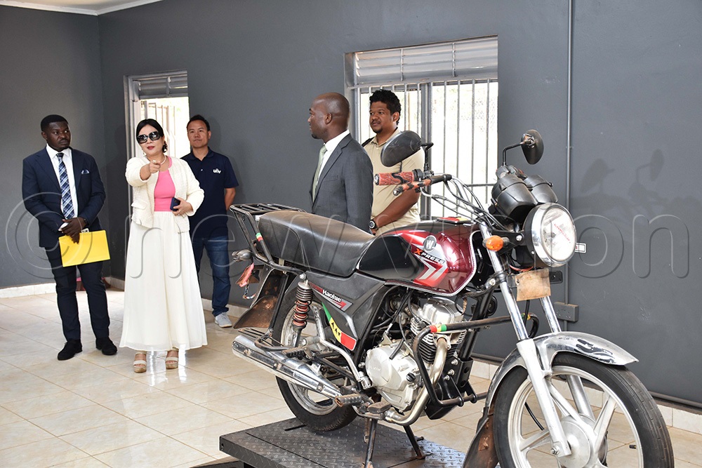 Wang Lihong, director of Luyanzi Institute of Technology (white), sharing a moment with Anthony Mula, the director general of Busoga Consortium (grey suit), as other officials look on.  This was at Luyanzi Institute in Kiira (Photo by Simon Peter Tumwine)