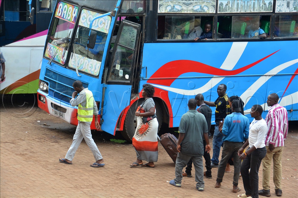 A passenger pulls her suitcase to board a bus to western Uganda at Kisenyi Bus Terminal in Kampala on Friday 12, 2025.