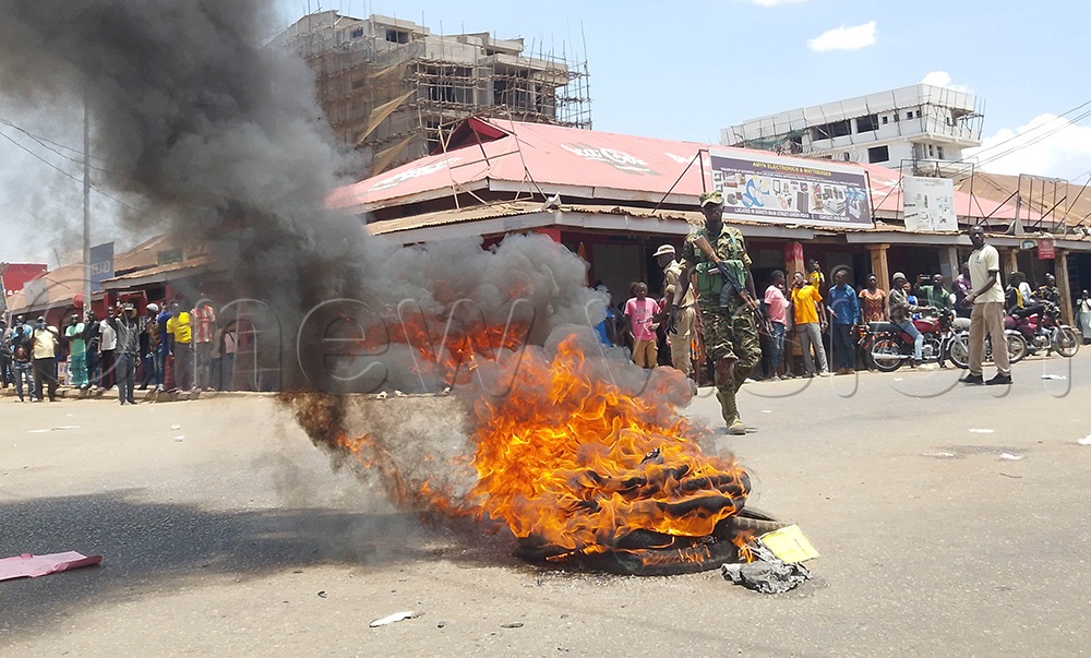 A fire the tyres that were burnt by FDC supporters during the demonstration. (Photo by Godfrey Ojore)