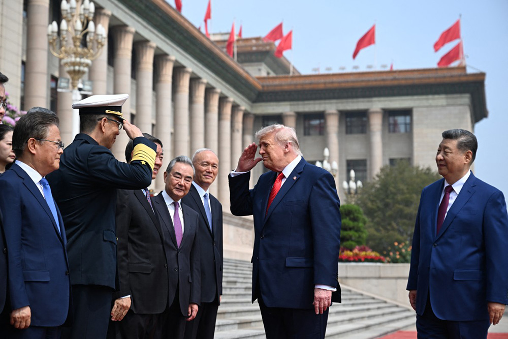 US President Donald Trump (C) salutes China's Defence Minister Dong Jun (2nd L) as China's President Xi Jinping (R) looks on at the Great Hall of the People in Beijing on May 14, 2026. (Photo by Kenny HOLSTON / POOL / AFP)
