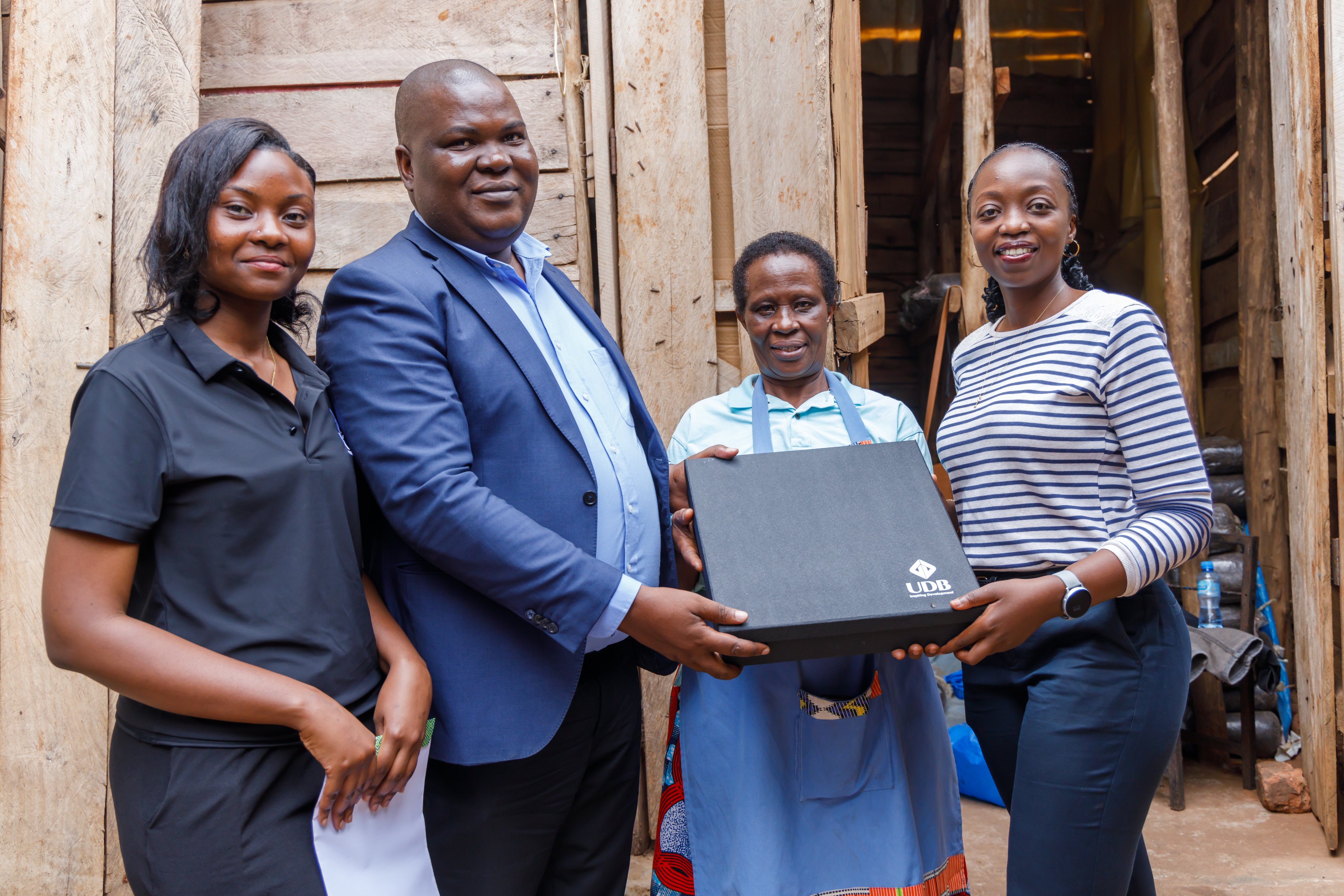 Ms. Asenanth Byaruhanga (2nd R) Poses With Udb Staff Who Paid A Courtesy Visit To Her Farm During The Customer Week In 2024