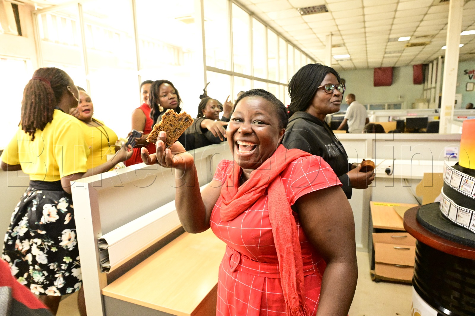 Omu ku bakozi ba Nv Eether Arinaitwe ng'alaga cake egabuddwa ku bikujjuko bya NV ebya 40yrs