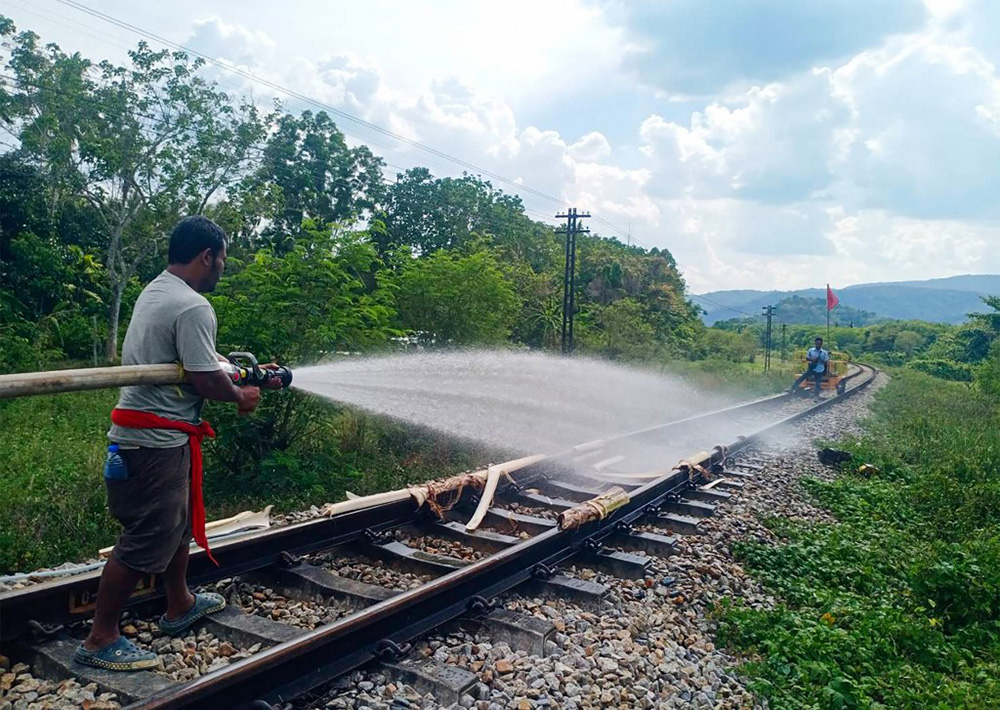 A worker spraying water on railway tracks warped by the heat between Ron Phibun district and Khao Chum in the southern Thai province of Nakhon Si Thammarat. (Photo by Handout / State Railway of Thailand / AFP) 