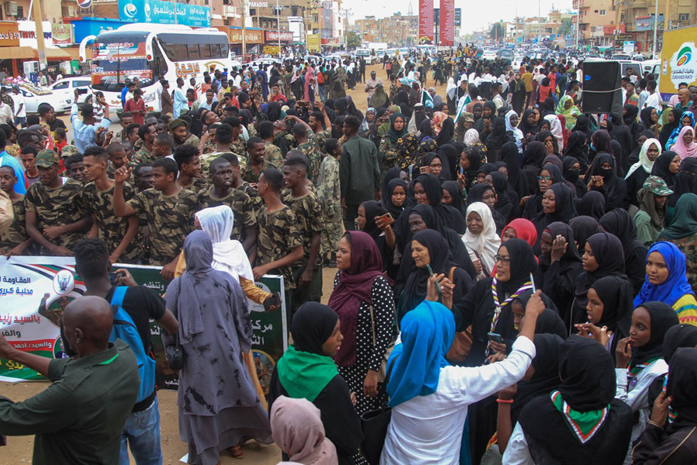 People and local fighters supporting the Sudanese army cheer during a visit by Kamil Idris (not pictured), a former UN official who was appointed in May as prime minister by Sudan's de facto leader Abdel Fattah al-Burhan, in Omdurman on July 19, 2025. (Photo by Ebrahim Hamid / AFP)