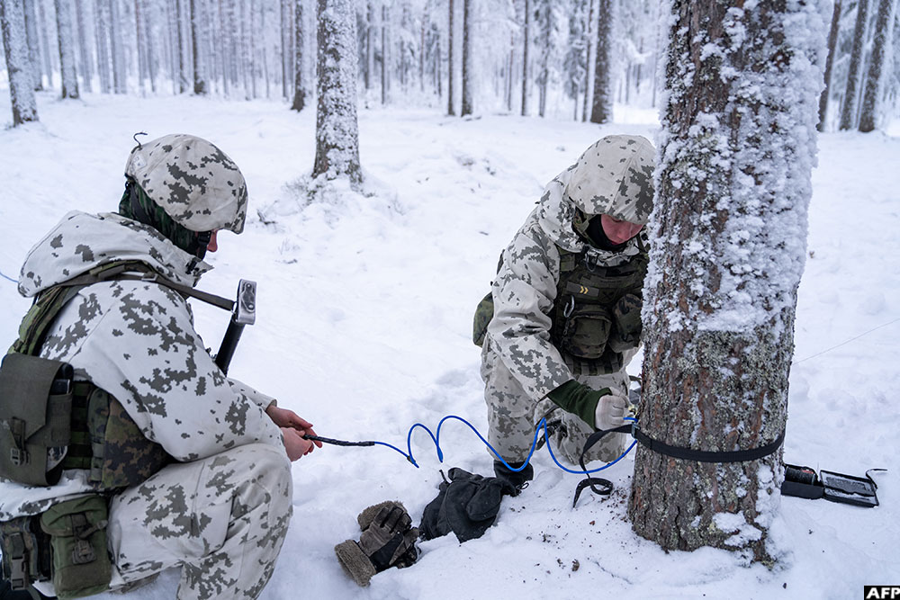 Finnish conscripts install anti personnel mines on a tree in a snow-covered forest at the Kainuu Brigade in Kajaani, Finland.