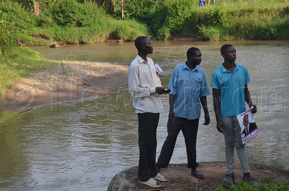 Locals who were holding Muntu's posters on the Manafwa River where the bridge collapsed. (Photo by Isaac Nuwagaba)