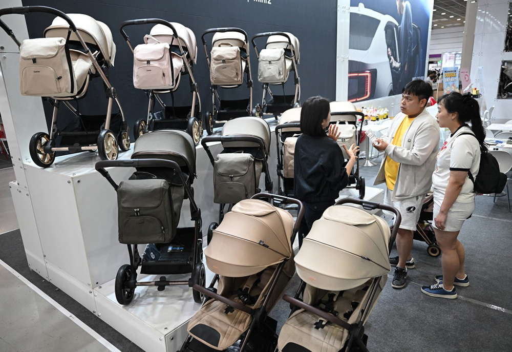 This picture taken on April 30, 2026 shows visitors looking at strollers at a booth during a baby fair in Seoul. South Korea has one of the world's lowest birth rates, and the government has spent billions of dollars trying to encourage citizens to have more babies. (Photo by Jung Yeon-je / AFP)