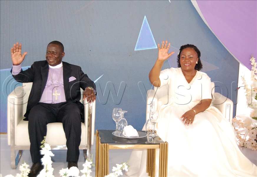 Bishop Moses Banja and his wife, Canon Prof. Olivia Banja, wave to their guests upon arrival at their reception venue at Mengo Senior School. (All Photos by Mathias Mazinga)