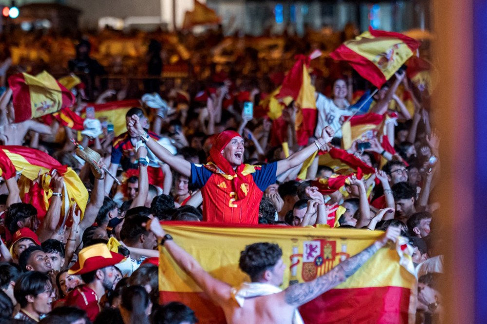 Fans of the Spanish national football team celebrate their team's victory at the Fan Zone in Plaza Colon, Madrid on July 19, 2026, after Spain defeated Argentina 1-0 in extra time in the 2026 FIFA World Cup final. (Credit: AFP)
