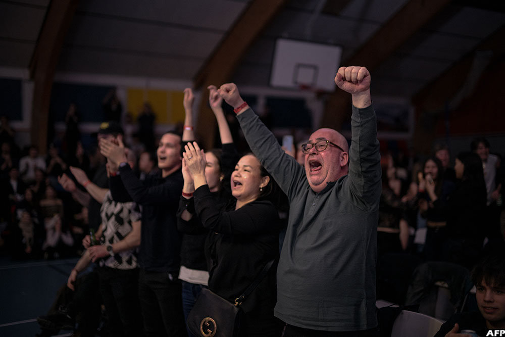 Members of the crowd raise their arms and shout their support for the Greenlandic fighters during a boxing match in Nuuk, Greenland, on February 28, 2026