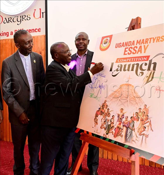 Dr. Christopher B. Mukidi (R), the Uganda Martyrs University deputy vice chancellor, appending his signature on the launch pad for the Uganda Martyrs Essay Competition at the main university campus in Nkozi, Mpigi district. The competition is expected to attract pre-university students from the association of Member Episcopal Conferences in Eastern Africa (AMECEA) region. The launch was held on Feb 19,2026. (All photos by Eddie Ssejjoba)