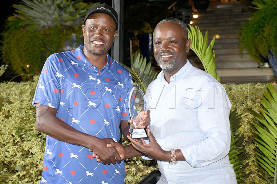 EALA captain Kanini Kega (left) presents a trophy to Thomas Tayebwa after the EAC Inter-Parliamentary Games Golf tournament at the Lake Victoria Serena course. Photo by Michael Nsubuga