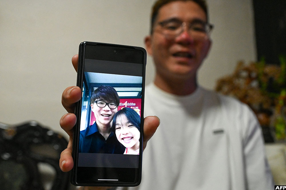 Singapore's Delfard Tay shows a photo with his late daughter Shermaine