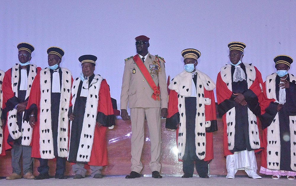 Guinea junta leader Colonel Mamady Doumbouya, poses with members of the judiciary at his swearing in ceremony as president of country transion on October 1, 2021 in Conakry. The head of the junta in Guinea, Colonel Mamady Doumbouya, was sworn in on Friday as president of this West African country for a period of transition of still unknown duration and content. (AFP Photo)