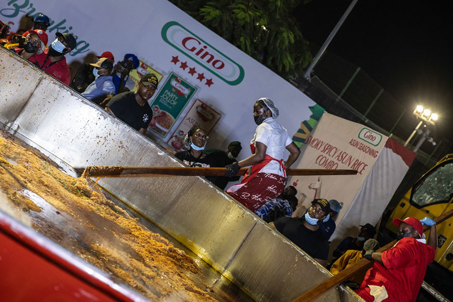 Nigerian chef Hilda Baci (L) stirs rice in a giant pot during an attempt to break the world record for the largest pot of Jollof rice, led by Nigerian chef Hilda Baci in Lagos. AFP PHOTO