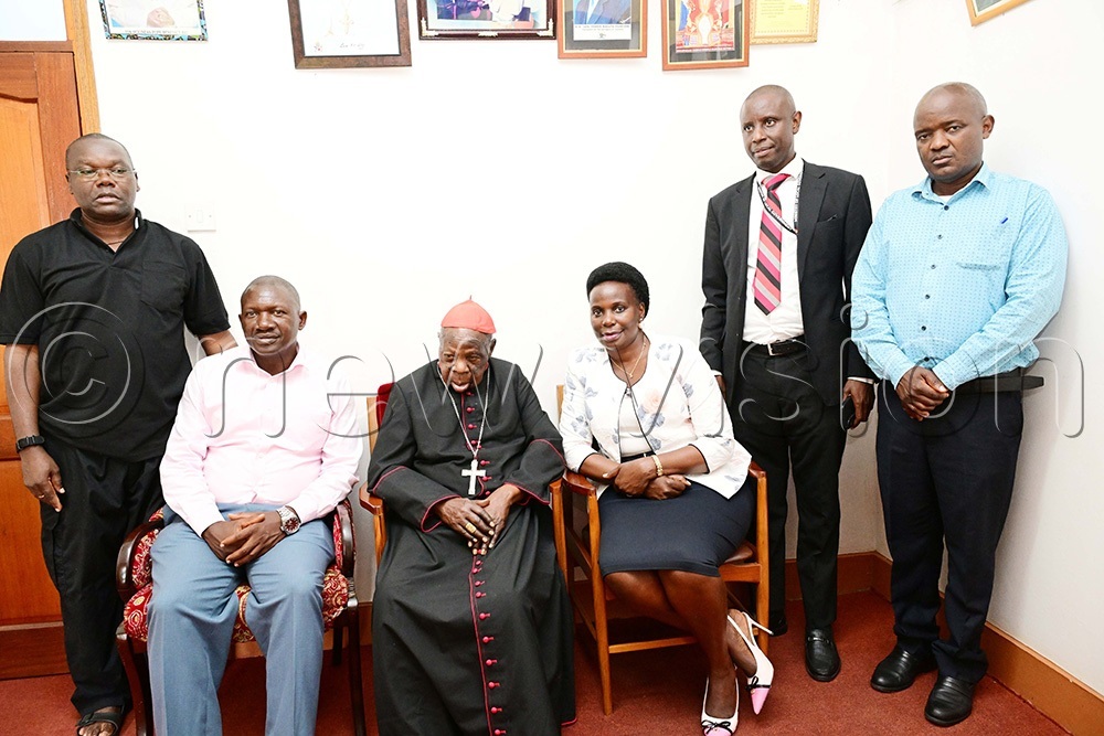 Charles Magumba, a commissioner in the Ministry of Local Government, and other officials pose for a picture with Cardinal Emmanuel Wamala, seated, after handing over documents of a new car donated by President Museveni. It was handed to him at his home in Nsambya on August 3, 2026. (Photo by Eddie Ssejjoba)