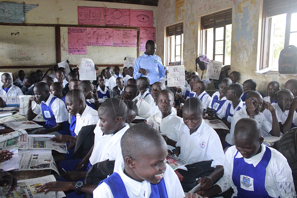Teacher John Bosco Oola uses PASS PLE in class with candidates, saying the publication's standard questions and answers help them prepare for their examinations. (Photo by Ritah Mukasa)