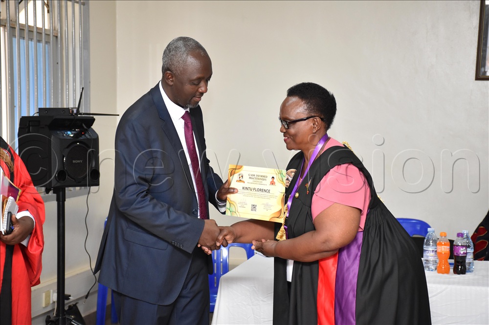 Justice Andrew Khaukha, Executive Director of Judicial Training Institute (JTI) awarding certificate to Kintu Florence during the inaugural graduation of participants in the Gerontological Alternative Dispute Resolution (GADR) Training at St. Francis Chapel, Makerere University. 